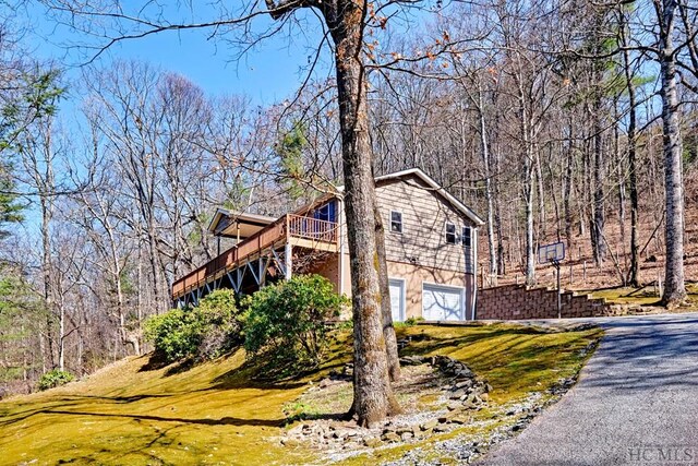 view of property exterior with a garage and a deck