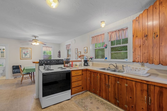 232 Dobson Rd, Franklin, NC 28734 - kitchen featuring electric range oven, a sink, light countertops, brown cabinets, and a peninsula