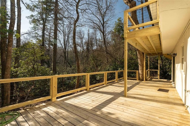 wooden terrace with view of wooded area