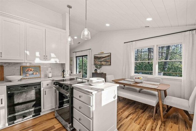 kitchen featuring stainless steel range with electric cooktop, a peninsula, light wood-type flooring, light countertops, and white cabinetry