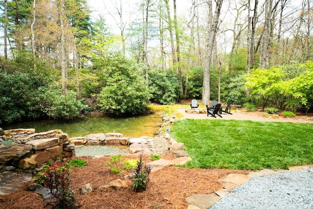 view of grassy yard with an outdoor fire pit