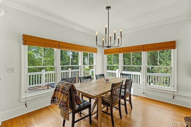 dining space featuring ornamental molding, a chandelier, and light hardwood / wood-style floors