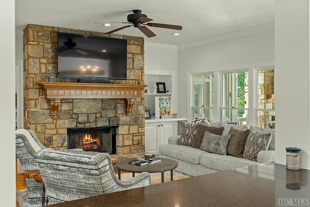 living room featuring crown molding, ceiling fan, and a fireplace