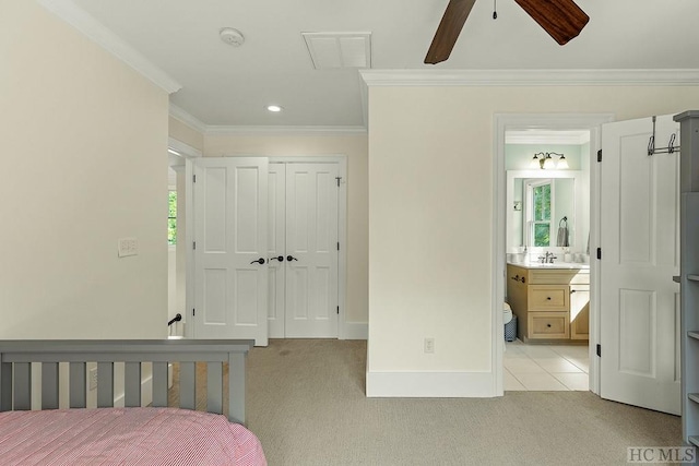 carpeted bedroom with ceiling fan, ensuite bath, crown molding, and a closet