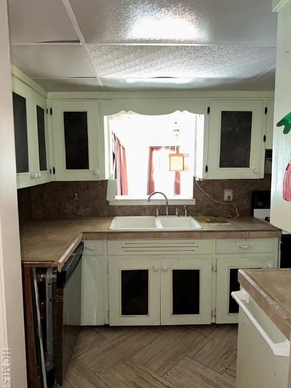 kitchen featuring sink, backsplash, tile counters, and light parquet flooring