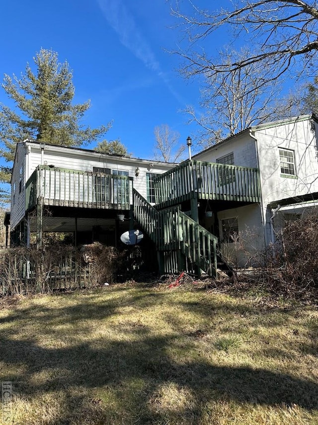 rear view of house with a wooden deck and a lawn