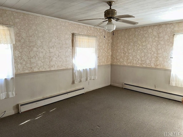 carpeted spare room with a baseboard radiator, ornamental molding, and a healthy amount of sunlight