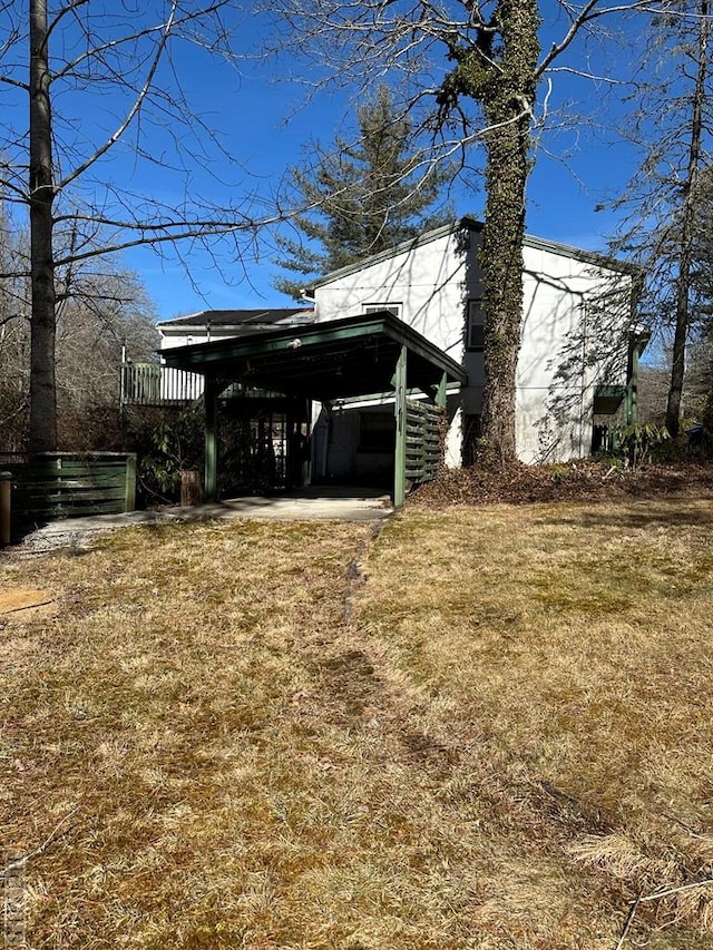 view of side of home with a carport and a yard