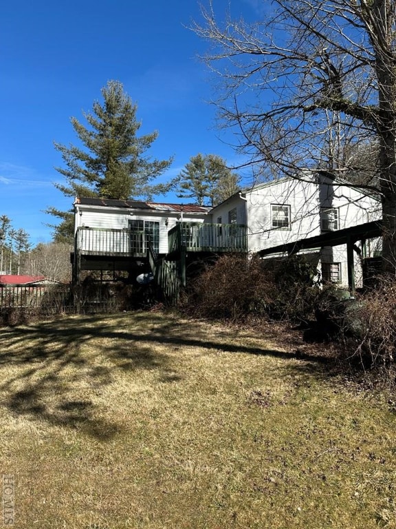 back of house with a lawn and a wooden deck