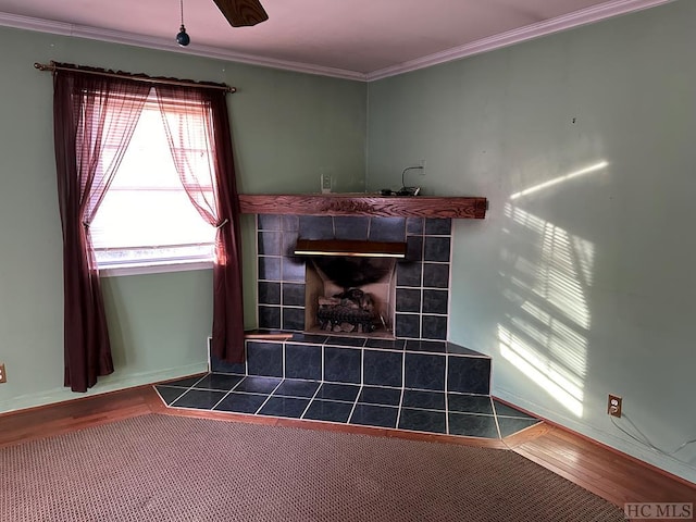 room details featuring a tiled fireplace, wood-type flooring, and crown molding