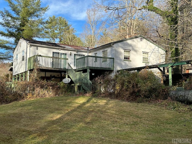 rear view of house with a wooden deck and a lawn