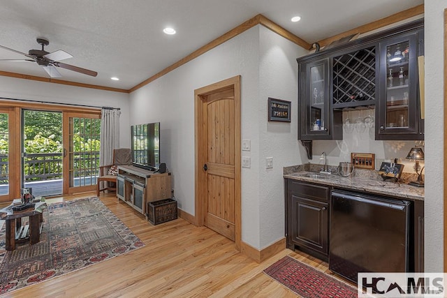 indoor wet bar with ornamental molding, light wood finished floors, ceiling fan, fridge, and a textured wall