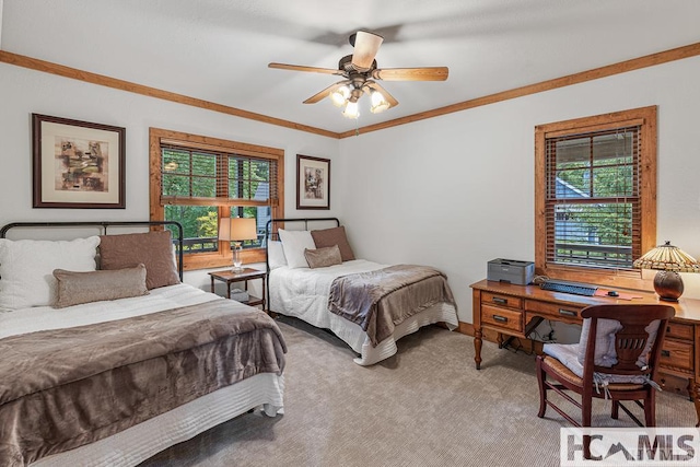 carpeted bedroom with multiple windows, baseboards, ornamental molding, a desk, and ceiling fan