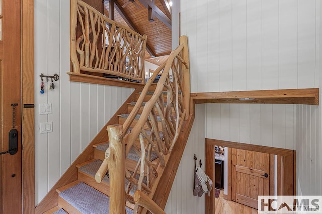 staircase with wooden walls and wood ceiling
