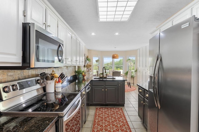 150 Lauren Ln, Franklin, NC 28734 - kitchen featuring appliances with stainless steel finishes, a peninsula, dark countertops, white cabinetry, and recessed lighting