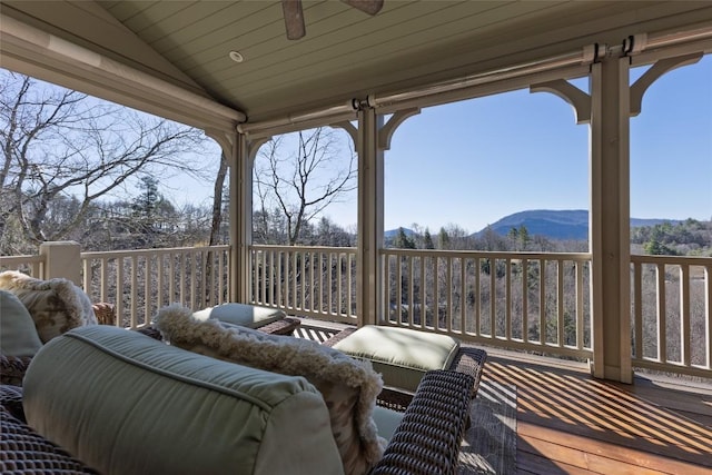 wooden deck with an outdoor living space and a mountain view