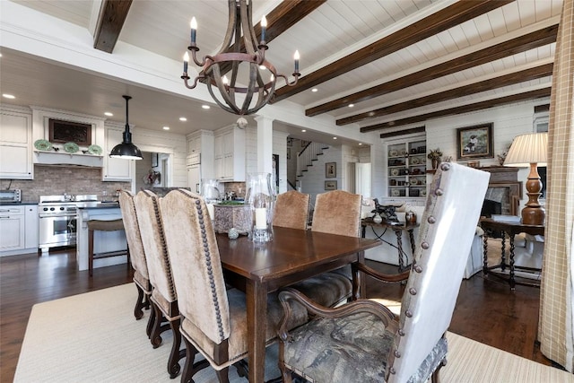 dining room featuring beam ceiling, dark wood-type flooring, a chandelier, and stairs