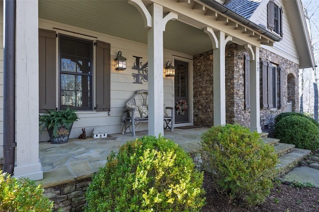 property entrance with stone siding and a porch