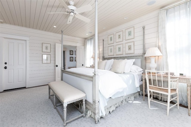 bedroom with carpet floors, wood ceiling, wood walls, and a ceiling fan