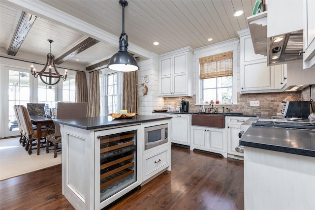 kitchen with wine cooler, dark countertops, dark wood-style flooring, and white cabinetry