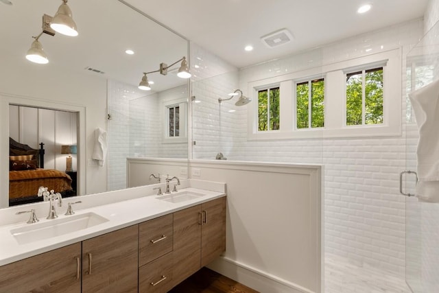 842 N High Mountain Dr, Cashiers, NC 28717 - ensuite bathroom featuring tiled shower, double vanity, recessed lighting, and wood finished floors