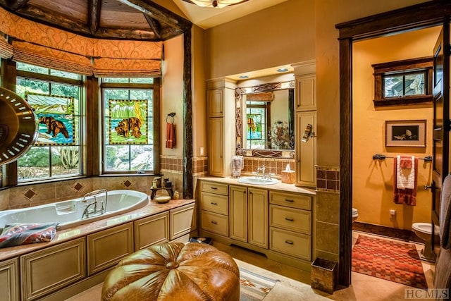 bathroom featuring vanity, a bathing tub, tile patterned floors, and toilet