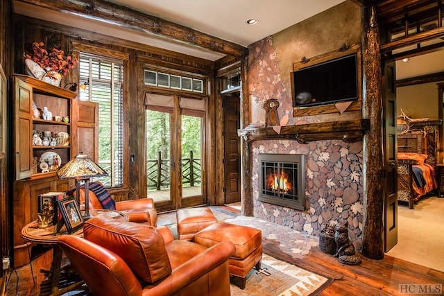 living area featuring beamed ceiling and a fireplace