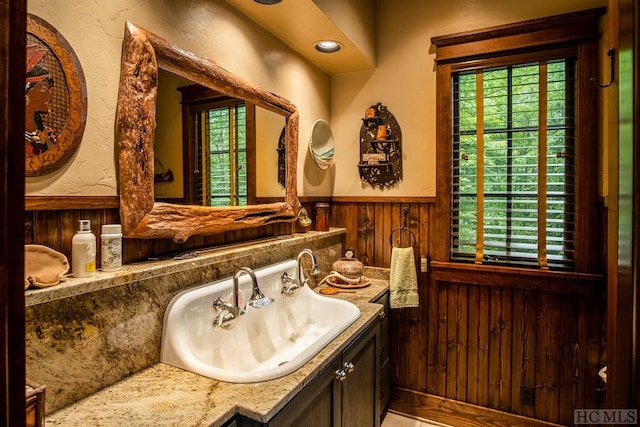 bathroom featuring vanity and wood walls