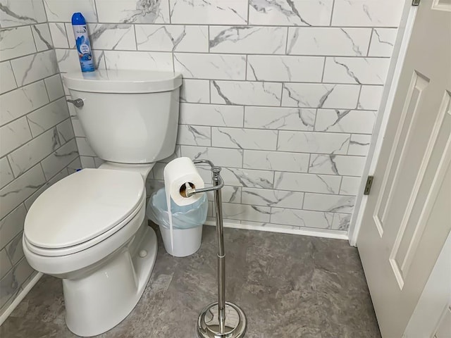 bathroom with toilet and tile walls