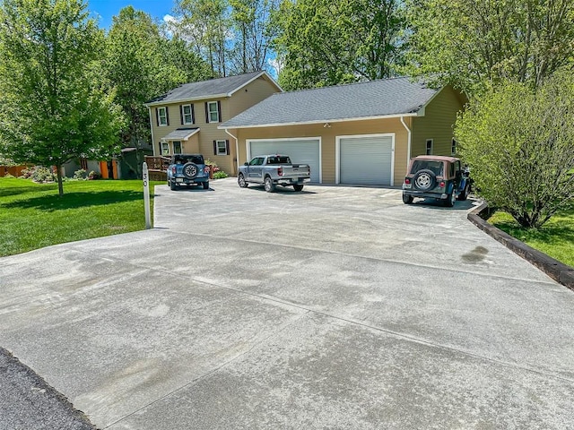 view of front of house with a garage, concrete driveway, and a front yard