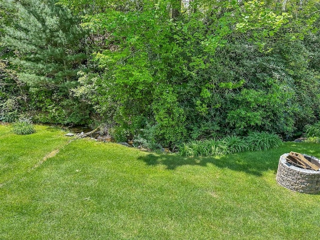 view of grassy yard featuring a fire pit