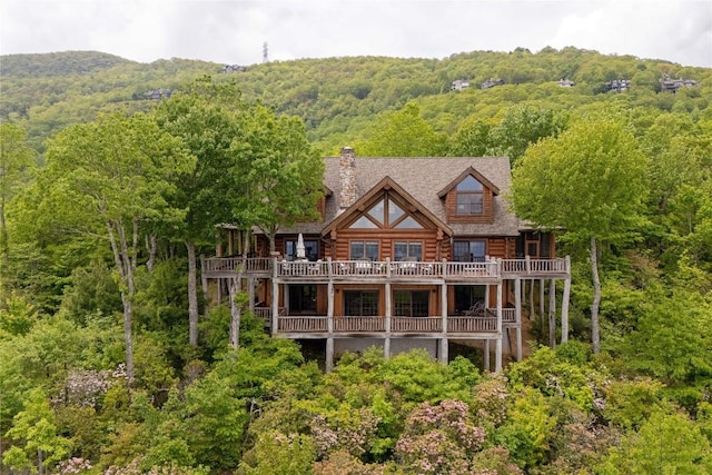 865 Toxaway Dr, Lake Toxaway, NC 28747 - back of property featuring log exterior, a wooded view, a balcony, and a chimney