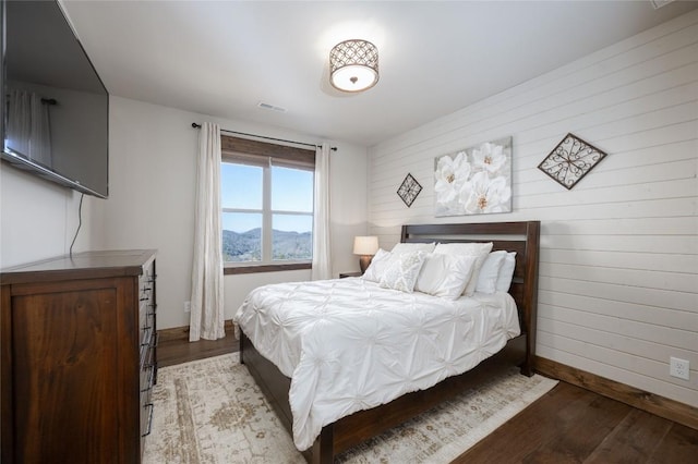 bedroom featuring visible vents, light wood-style flooring, and baseboards