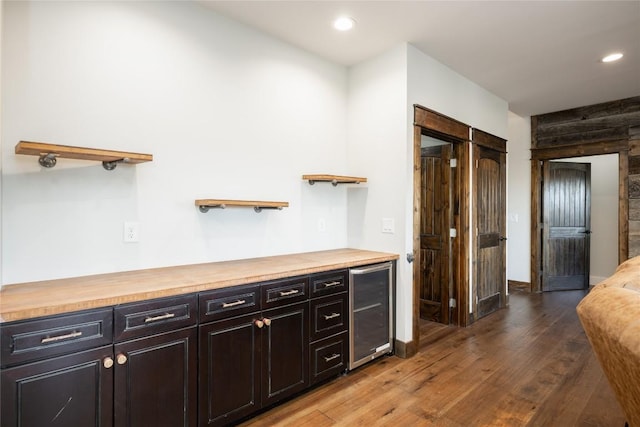 interior space featuring beverage cooler, butcher block countertops, wood finished floors, open shelves, and recessed lighting