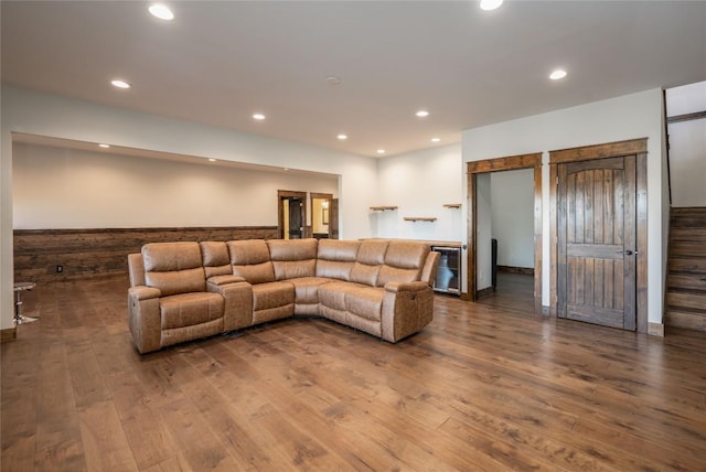 living area featuring wainscoting, stairway, dark wood-type flooring, and recessed lighting