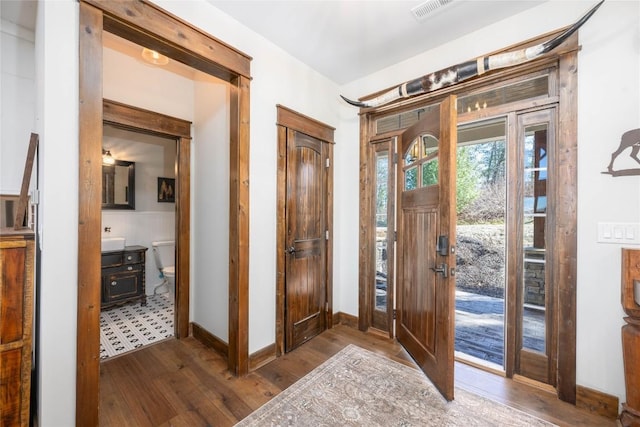 entrance foyer with hardwood / wood-style floors, visible vents, and baseboards