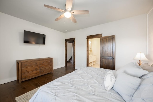 bedroom with baseboards, ceiling fan, ensuite bath, and wood finished floors