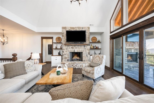 living room with a chandelier, dark wood-style flooring, a fireplace, and a towering ceiling