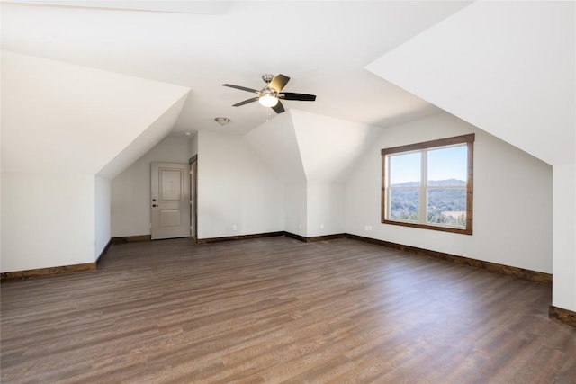 bonus room with a ceiling fan, vaulted ceiling, baseboards, and wood finished floors