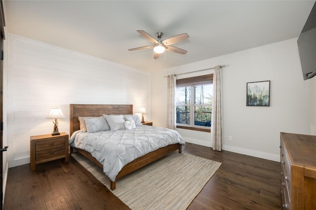 bedroom with dark wood finished floors, a ceiling fan, and baseboards