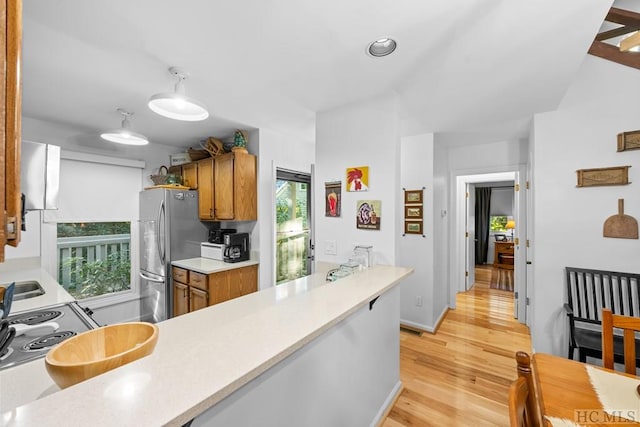 kitchen with stovetop, light hardwood / wood-style flooring, and stainless steel refrigerator