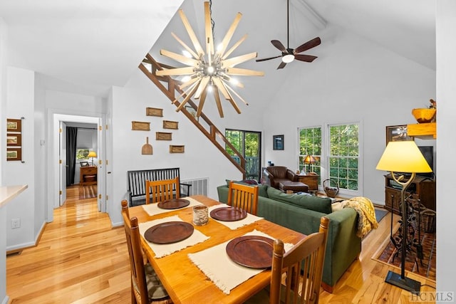 dining room with beam ceiling, high vaulted ceiling, a chandelier, and light wood-type flooring