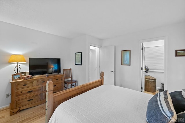 bedroom featuring connected bathroom and light wood-type flooring