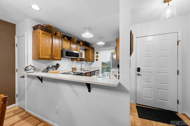 kitchen with stainless steel appliances, a kitchen bar, and kitchen peninsula