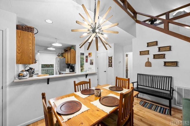 dining room with light hardwood / wood-style floors and a notable chandelier