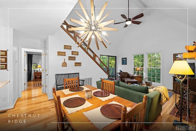 dining area with light wood-type flooring, visible vents, high vaulted ceiling, and a chandelier