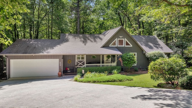 200 Blackberry Trl, Sapphire, NC 28774 - view of front of home featuring covered porch, driveway, a garage, a shingled roof, and a front lawn