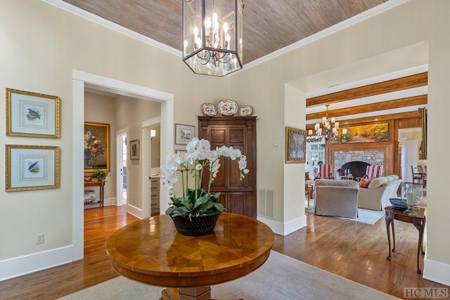 entrance foyer featuring crown molding, hardwood / wood-style floors, a notable chandelier, and wood ceiling