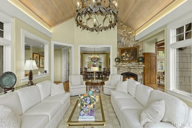 living room featuring wood ceiling, a stone fireplace, an inviting chandelier, and a wealth of natural light