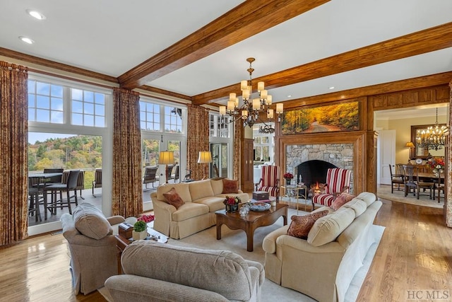 living room with beam ceiling, a wealth of natural light, a chandelier, and light hardwood / wood-style flooring